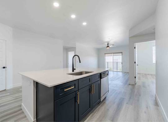 a white and black kitchen with a large counter top and a sink