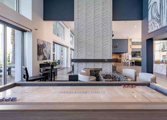 a shuffleboard table in a clubhouse with a fireplace
