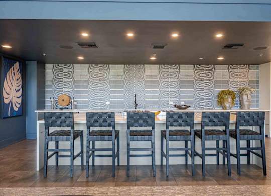 a large table with chairs in front of a wall with a geometric pattern