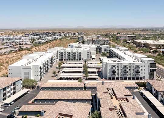 a cityscape of white buildings with a desert in the background