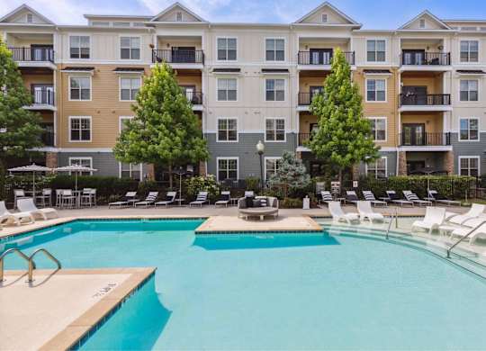 A large swimming pool in front of apartment buildings.