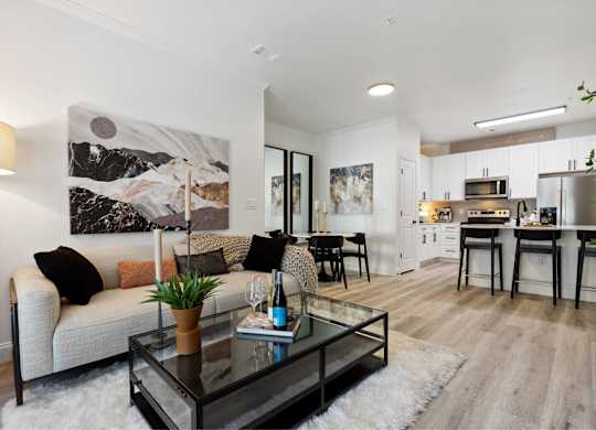 A modern living room with a white couch and a large painting on the wall.