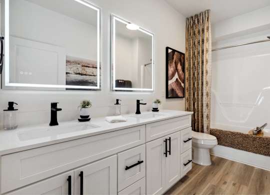 A bathroom with two sinks and a large mirror.