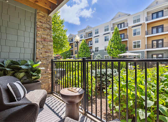 A balcony with a chair and table in front of a building.
