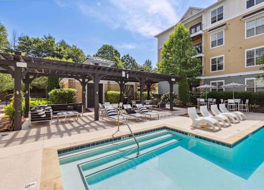 A large outdoor swimming pool with a slide and sun loungers.