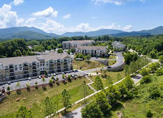 A large building complex with a parking lot in front of it.