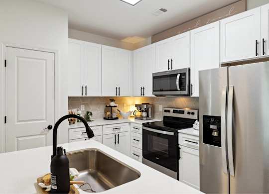 A modern kitchen with a stainless steel refrigerator and a black microwave above the stove.