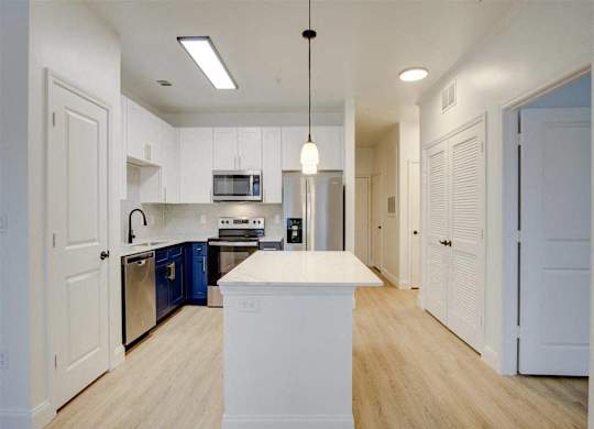 A kitchen with white cabinets and a white island.