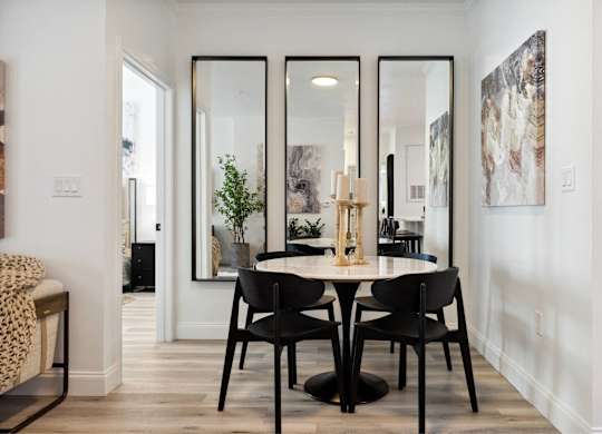 A dining room with a table and chairs.