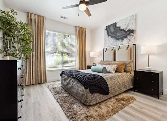 A bedroom with a bed, a ceiling fan, and a rug.