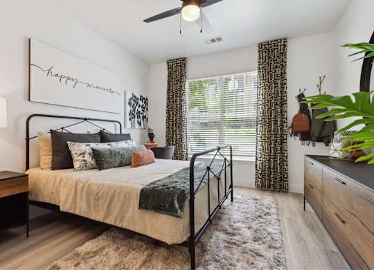 A bedroom with a bed, a ceiling fan, and a rug.
