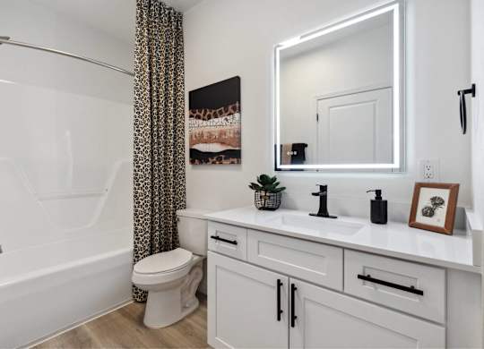 A white bathroom with a toilet, sink, and shower.