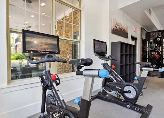 A stationary bike and a treadmill are in a room with a TV.