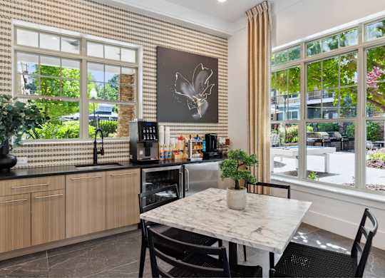 A kitchen with a table and chairs in front of a window.
