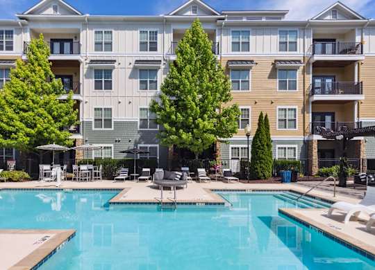 A large apartment complex with a pool in the foreground.