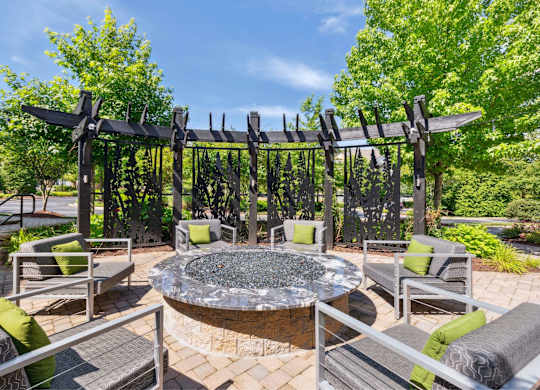 A patio with a fire pit and seating area.