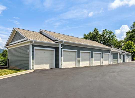A large garage with multiple doors is situated in a parking lot.