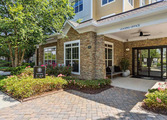A leasing office is located in a building with a brick facade and a landscaped front yard.
