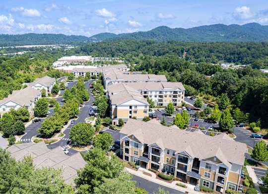 A bird's eye view of a residential complex surrounded by trees.