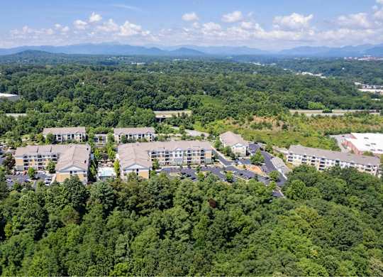 A bird's eye view of a large building surrounded by trees.
