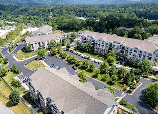 A bird's eye view of a residential area with multiple buildings and cars.