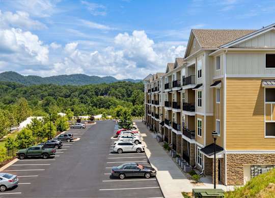 A parking lot with cars and apartment buildings in the background.