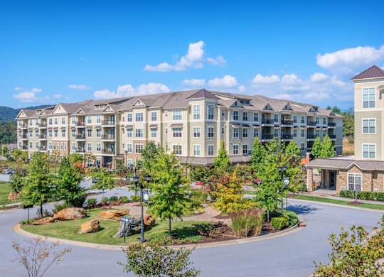 A large apartment complex with a round driveway in front.