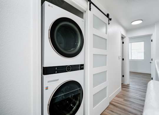 A white LG washing machine and dryer in a small laundry room.