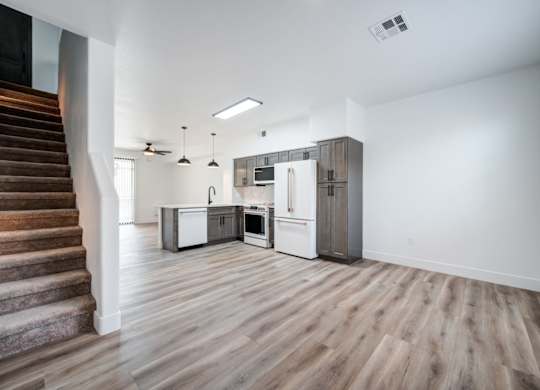 A kitchen with a refrigerator, oven, and microwave is shown.