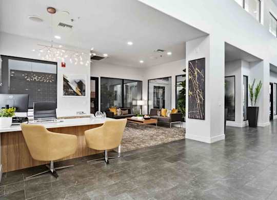 A modern office space with a desk, chairs, and a laptop.