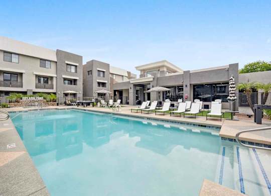 A large swimming pool in front of apartment buildings.
