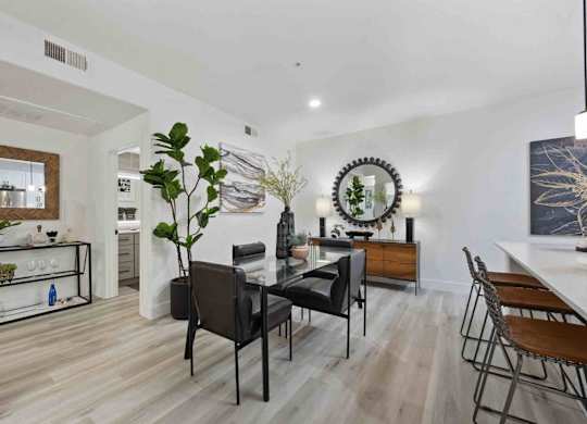 A modern dining room with a wooden table and chairs.