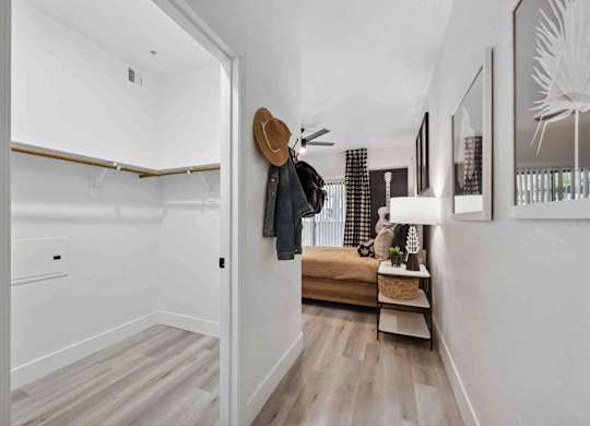 A hallway with a bench and a coat rack.