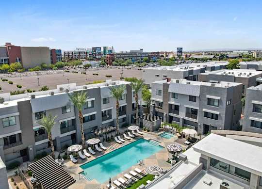 A large apartment complex with a pool in the middle.