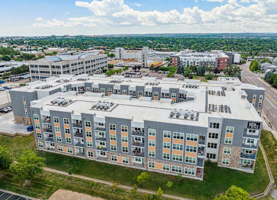 a large building with many windows and a green field in the background