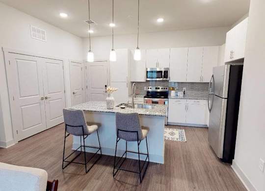A kitchen with a table and chairs in the middle of the room.