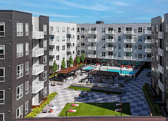A large apartment complex with a pool and a checkerboard patterned area.