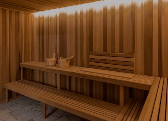 A wooden sauna with benches and towels.
