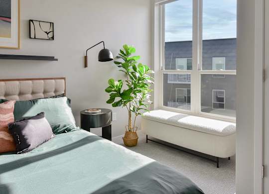 a bedroom with a bed and a large window at The Hallon Apartments, Minnesota