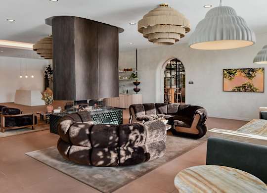 A modern living room with a large circular column and a variety of seating options.