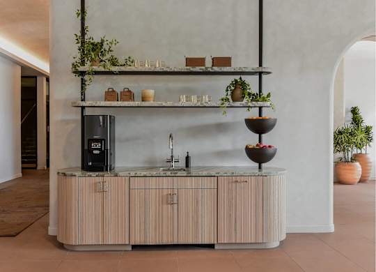 A modern kitchen with a wooden counter and a black fridge.
