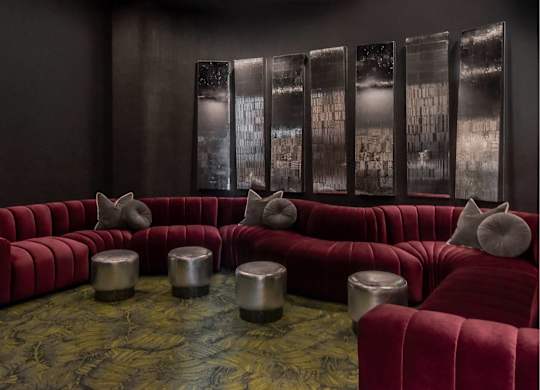A room with a red couch and a glass wall.