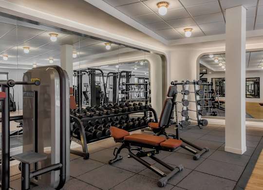 A gym with a variety of equipment including weights and machines.