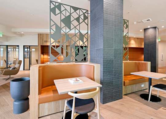 A modern dining area with a wooden table and chairs.