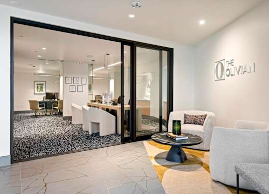 A modern living room with a glass door leading to a dining area.