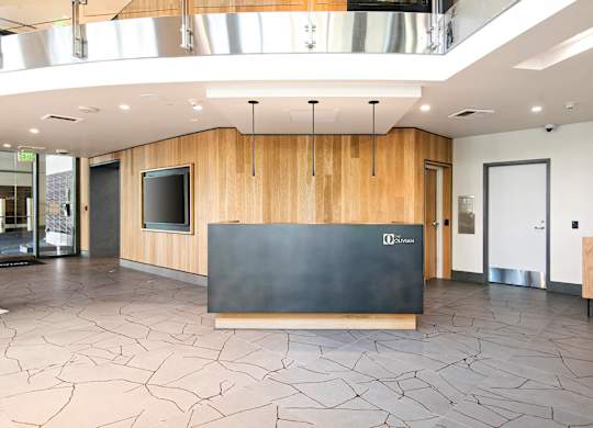 A reception area with a black counter and wooden walls.