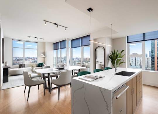 A modern kitchen with a marble island and a dining table with chairs.