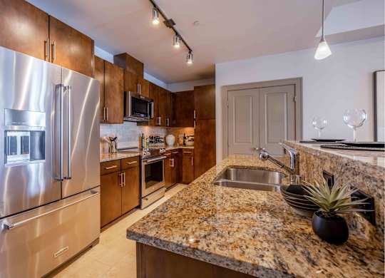 A kitchen with granite countertops and stainless steel appliances.