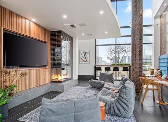 A modern living room with a grey sofa and a flat screen TV mounted on a wooden wall.