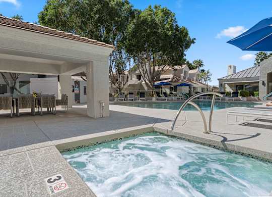 A hot tub in the middle of a pool surrounded by a building.